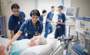 Two doctors preparing elderly patient before medical procedure