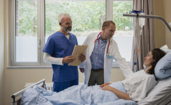 Doctors making rounds, talking with patient in hospital room