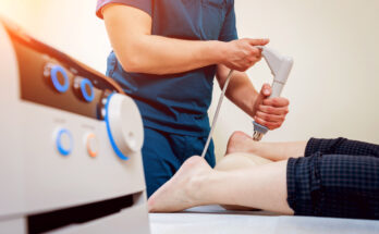 Shock wave therapy. The magnetic field, rehabilitation. Physiotherapist doctor performs surgery on a patient's heel