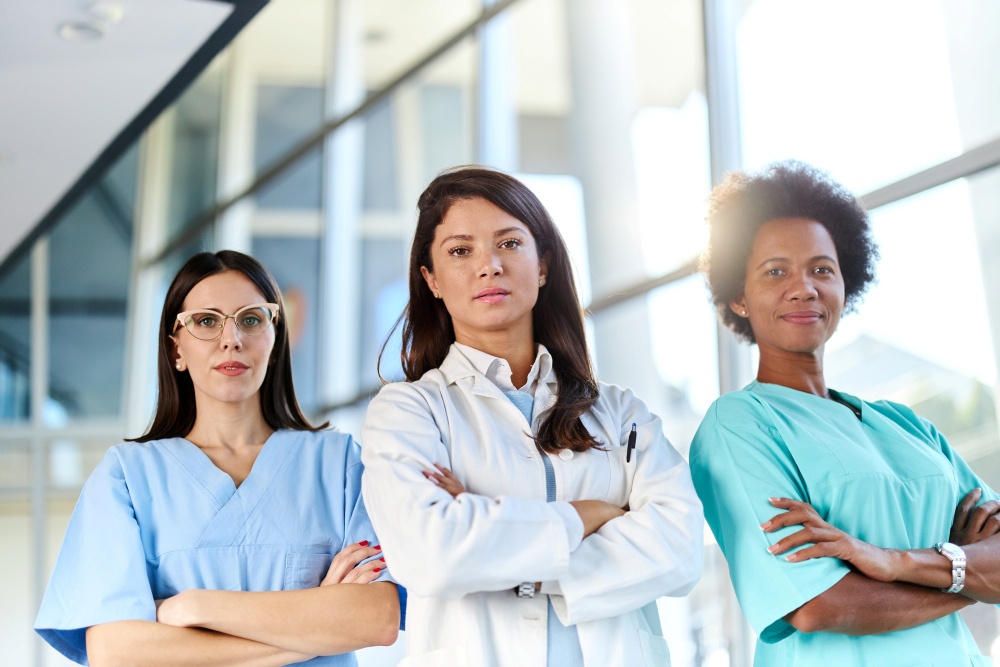 Portrait of female doctors standing in the hospital with crossed arms and looking at camera.
