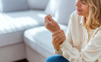 Senior woman suffering from pain in hand at home