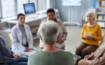 Back view at senior woman sitting in circle at mental health support group in retirement home