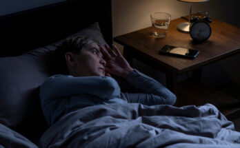 Depressed senior woman lying in bed cannot sleep from insomnia