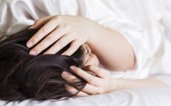 Sick woman on the bed at home with headache