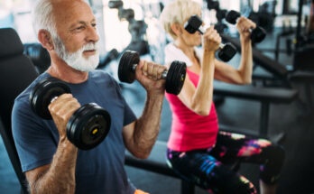 Senior fit couple exercising in gym to stay healthy