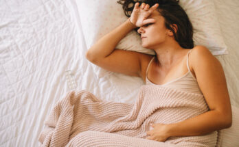 Sick young woman in bed.