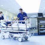 Two medics rushing with gurney in hospital emergency room