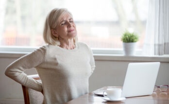 Upset mature middle aged woman feels back pain massaging aching muscles, sad senior older lady suffers from low-back lumbar pain sitting in incorrect sedentary posture, backache radiculitis concept